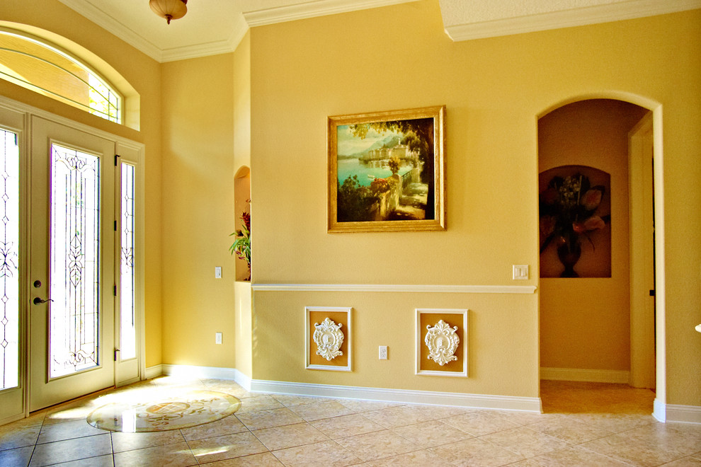 Ispirazione per un ingresso chic di medie dimensioni con pareti gialle, pavimento con piastrelle in ceramica, una porta singola, una porta bianca e pavimento marrone