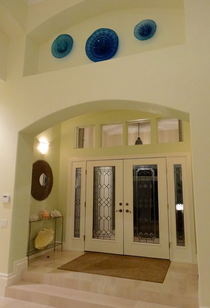 На фото: фойе среднего размера в стиле неоклассика (современная классика) с зелеными стенами, мраморным полом, двустворчатой входной дверью и стеклянной входной дверью с