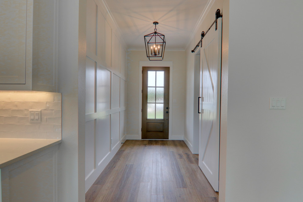 ダラスにある高級な中くらいなカントリー風のおしゃれな玄関ロビー (グレーの壁、クッションフロア、木目調のドア、茶色い床) の写真