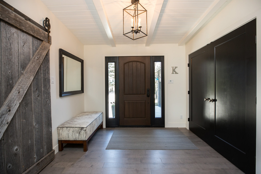 他の地域にあるコンテンポラリースタイルのおしゃれな玄関ドア (白い壁、濃色木目調のドア、グレーの床) の写真