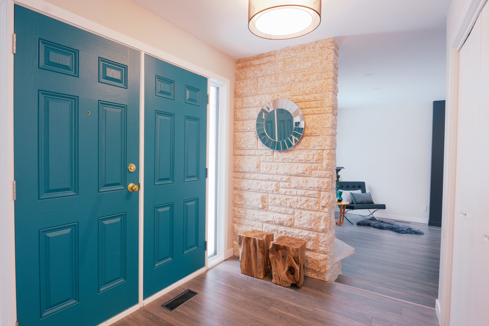 Aménagement d'un petit hall d'entrée rétro avec un mur beige, parquet clair, une porte double et une porte bleue.