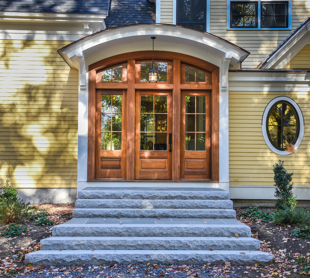 На фото: входная дверь среднего размера в морском стиле с желтыми стенами, гранитным полом, двустворчатой входной дверью и входной дверью из дерева среднего тона