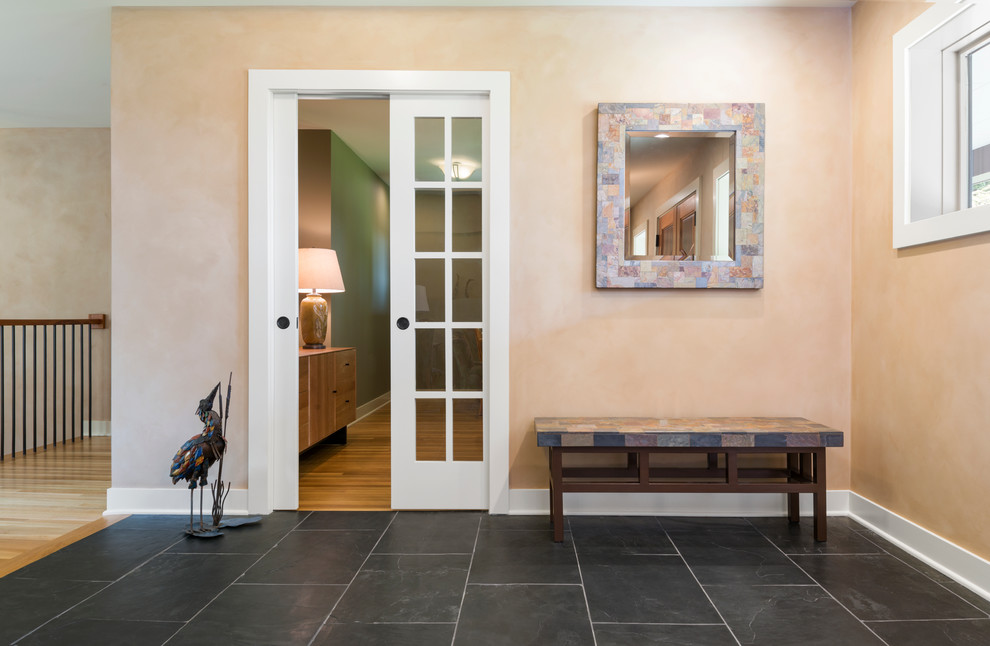 Ispirazione per un corridoio contemporaneo di medie dimensioni con una porta bianca, pareti beige, pavimento in ardesia, una porta a due ante e pavimento nero