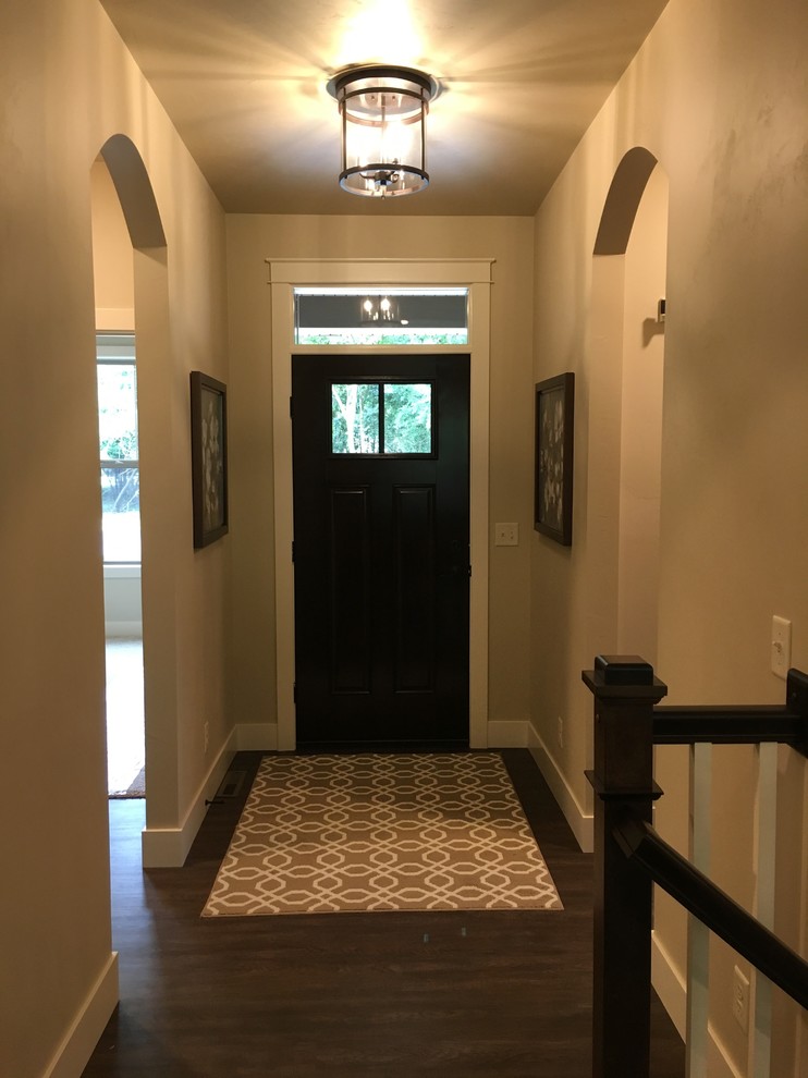 Cette photo montre un hall d'entrée moderne de taille moyenne avec un mur beige, un sol en vinyl, une porte simple, une porte marron et un sol marron.
