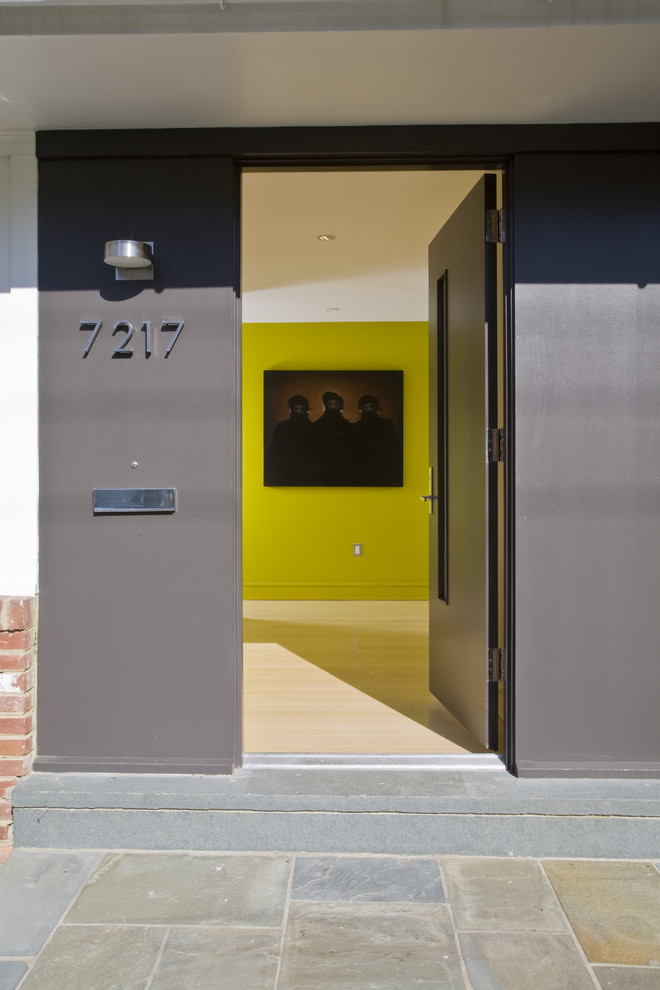 Foto på en funkis entré, med en enkeldörr och en grå dörr
