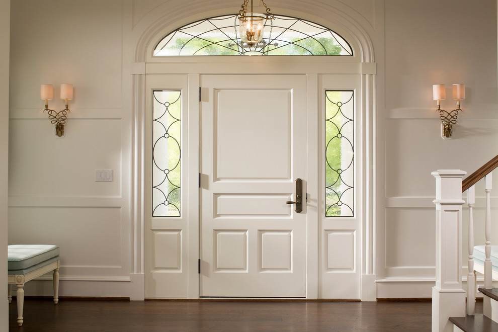 На фото: огромная входная дверь в классическом стиле с белыми стенами, темным паркетным полом, одностворчатой входной дверью и белой входной дверью с