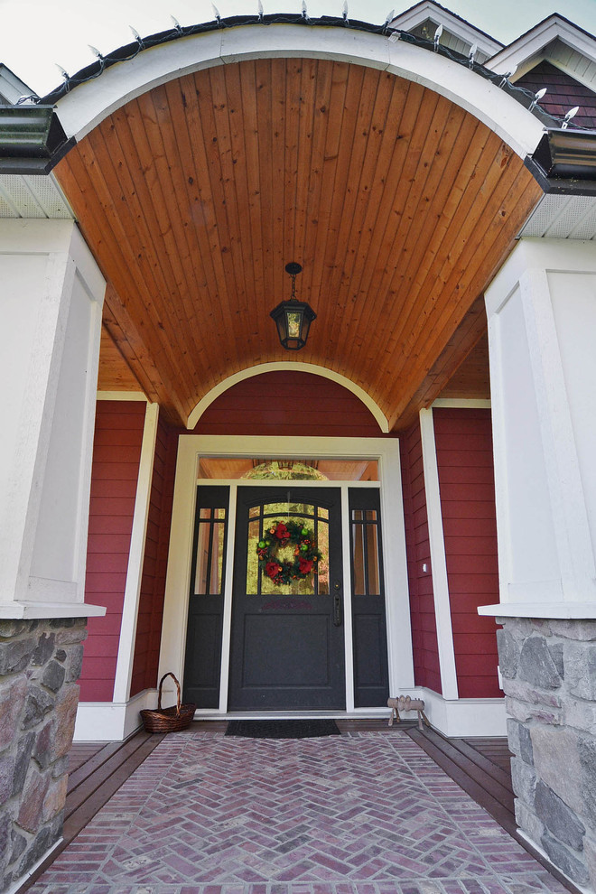 Rustikale Haustür mit Doppeltür, schwarzer Haustür, roter Wandfarbe und dunklem Holzboden in Vancouver
