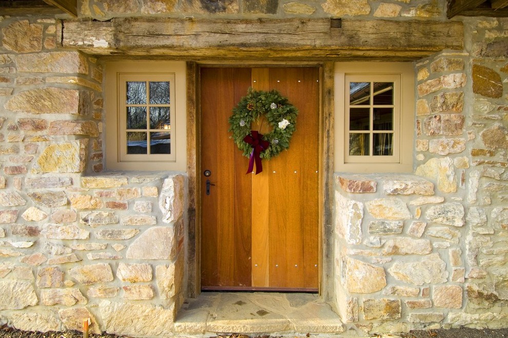 Immagine di una porta d'ingresso country di medie dimensioni con una porta singola, una porta in legno bruno e pareti beige