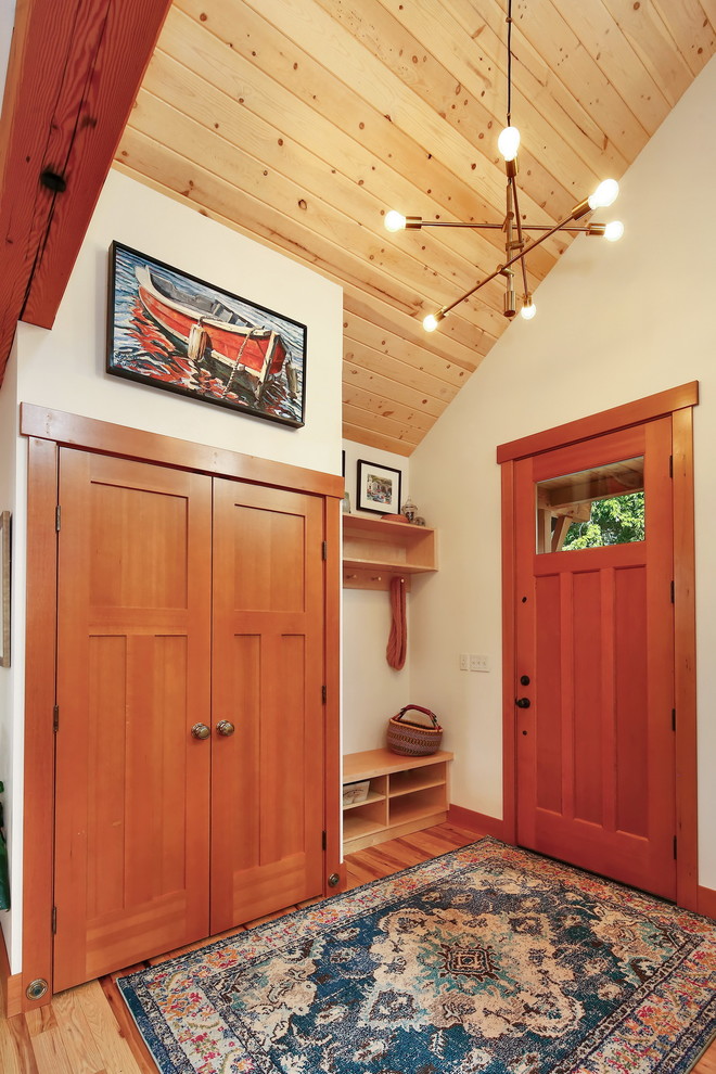 Ejemplo de puerta principal de estilo americano con paredes blancas, suelo de madera clara, puerta simple y puerta de madera en tonos medios