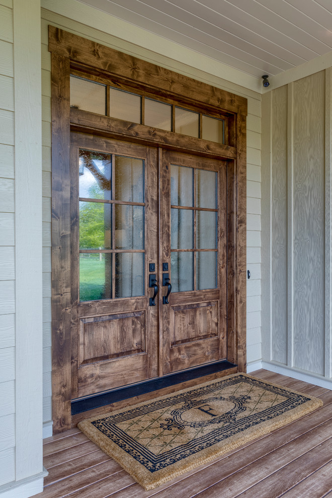 Idées déco pour une très grande porte d'entrée campagne avec un mur beige, un sol en bois brun, une porte double, une porte en bois brun et un sol marron.