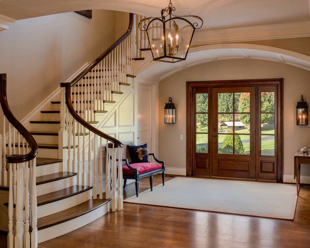 Klassisches Foyer mit beiger Wandfarbe, braunem Holzboden, Einzeltür und Haustür aus Glas in Philadelphia