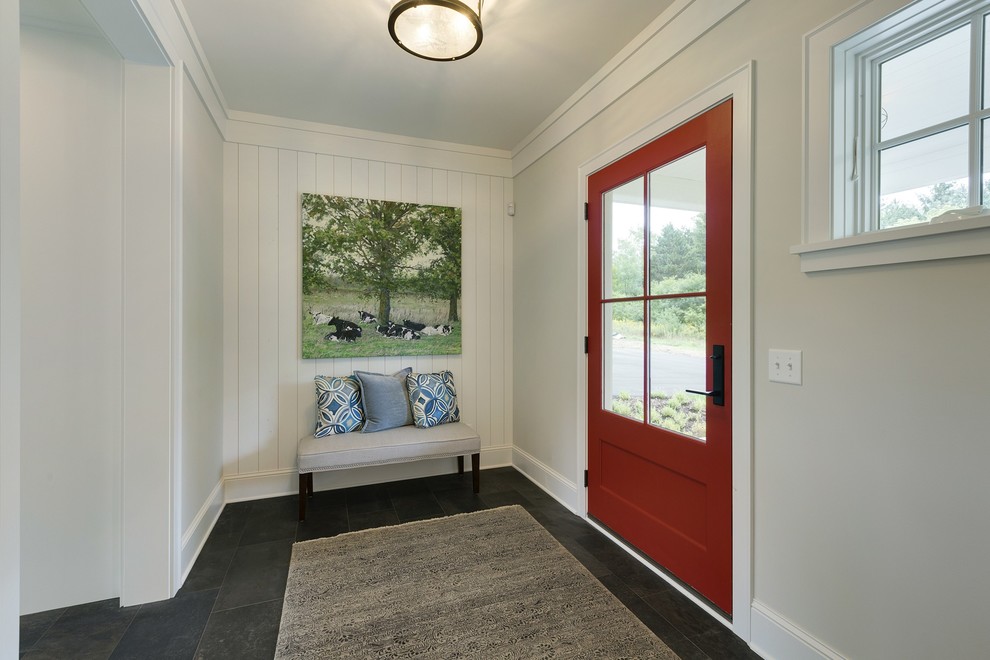 Aménagement d'une porte d'entrée campagne de taille moyenne avec un mur gris, un sol en ardoise, une porte simple, une porte rouge et un sol gris.