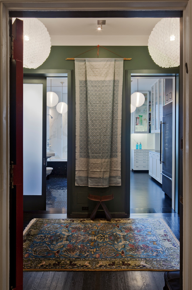 Cette image montre une petite entrée minimaliste avec un couloir, un mur gris, parquet foncé, une porte simple et une porte grise.