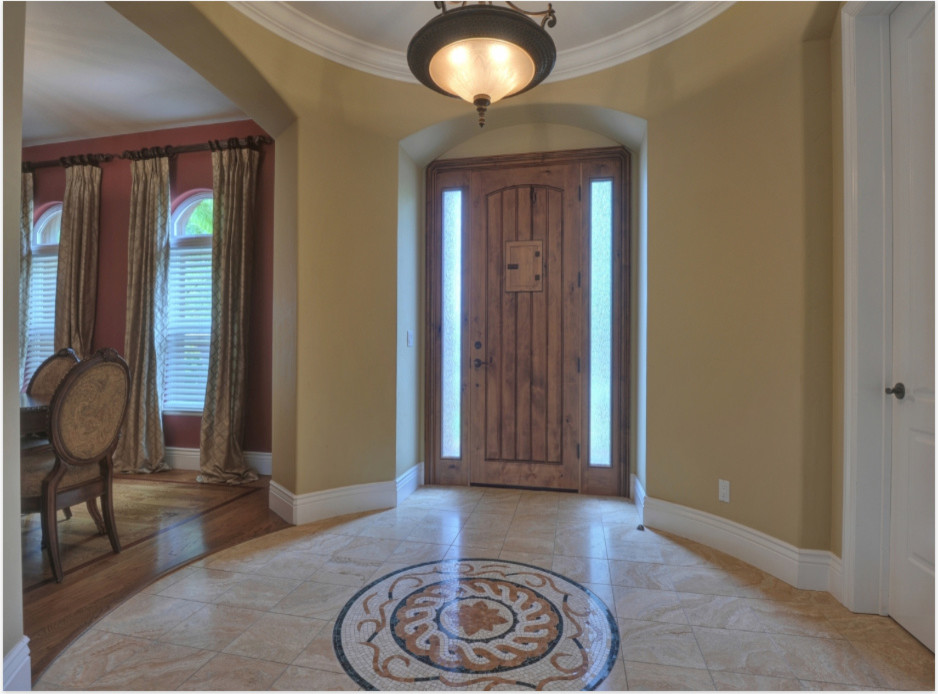 Example of a mid-sized tuscan marble floor entryway design in San Francisco with beige walls and a dark wood front door