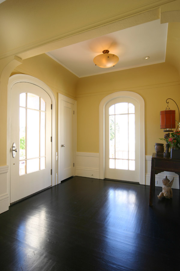 Inspiration for a mid-sized timeless dark wood floor entryway remodel in San Francisco with yellow walls and a white front door