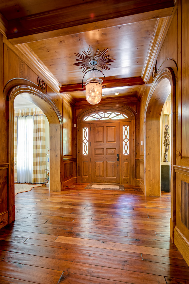 Réalisation d'un hall d'entrée tradition de taille moyenne avec un sol en bois brun, une porte simple et une porte en bois brun.