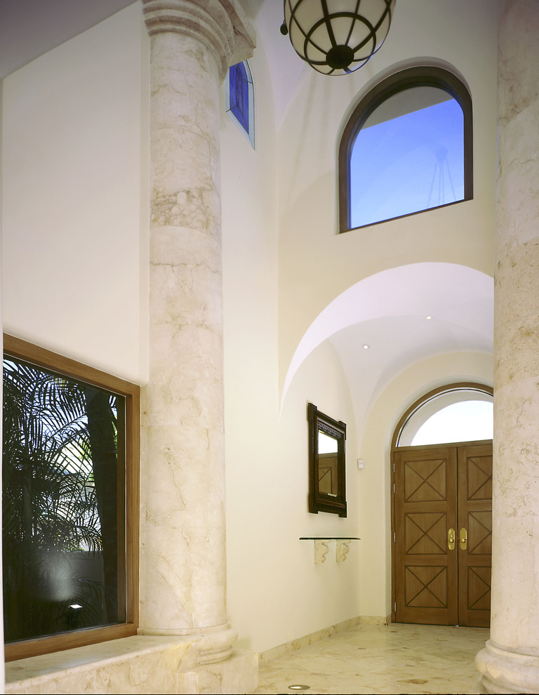 Cette image montre un hall d'entrée méditerranéen avec une porte double et une porte en bois brun.