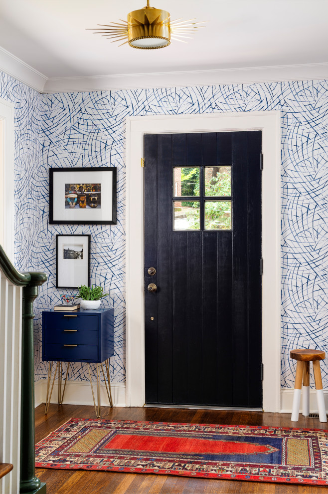 This is an example of an eclectic entrance in Atlanta with multi-coloured walls, medium hardwood flooring and a black front door.