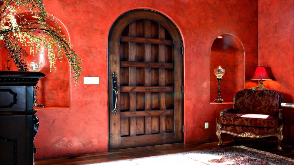 Expansive mediterranean foyer in Phoenix with red walls, a single front door and dark hardwood flooring.