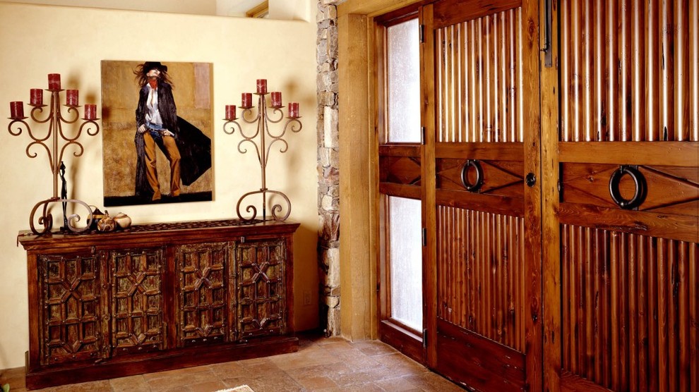 フェニックスにあるサンタフェスタイルのおしゃれな玄関ロビー (ベージュの壁、スレートの床、木目調のドア) の写真