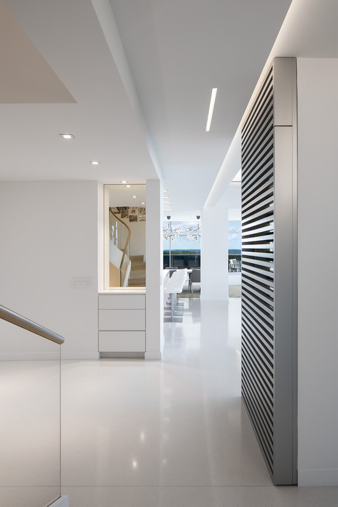This is an example of a contemporary entrance in Philadelphia with white walls, terrazzo flooring and white floors.