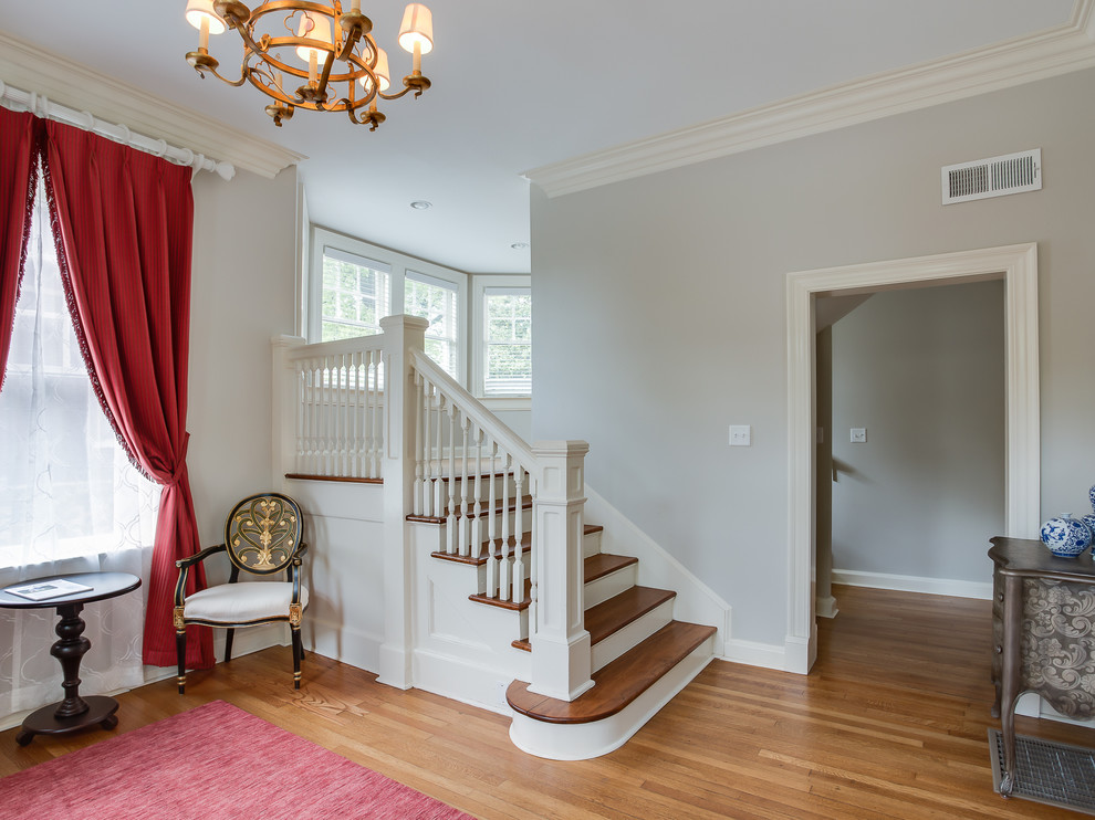 Großes Klassisches Foyer mit grauer Wandfarbe, braunem Holzboden, Einzeltür und weißer Haustür in Sonstige