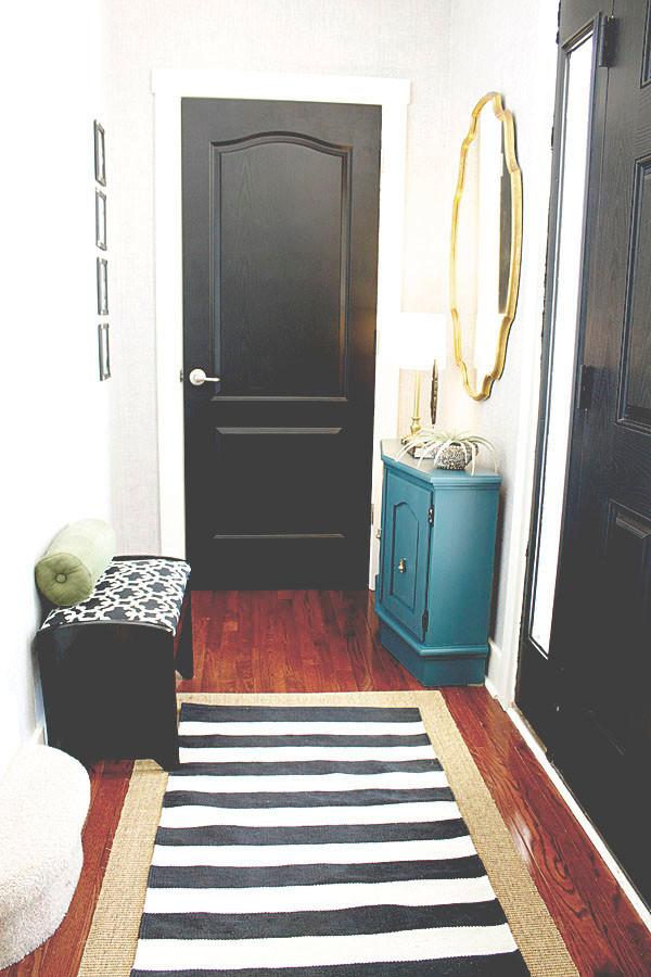 インディアナポリスにある低価格の小さなトランジショナルスタイルのおしゃれな玄関ロビー (黒い壁、濃色無垢フローリング、黒いドア) の写真