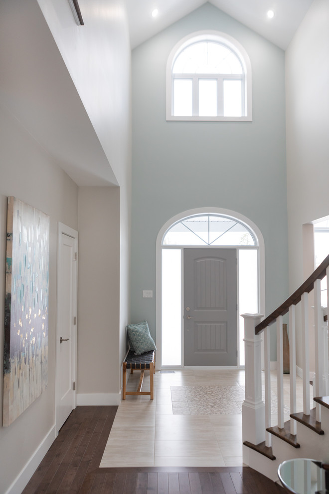 Идея дизайна: огромное фойе в классическом стиле с синими стенами, полом из керамической плитки, одностворчатой входной дверью и серой входной дверью