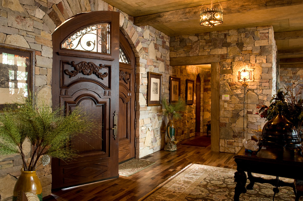 Diseño de entrada mediterránea con suelo de madera en tonos medios, puerta doble y puerta de madera oscura