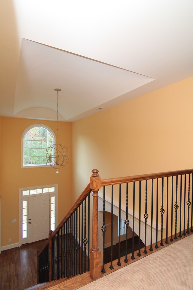 Example of a large transitional dark wood floor entryway design in Raleigh with yellow walls and a white front door