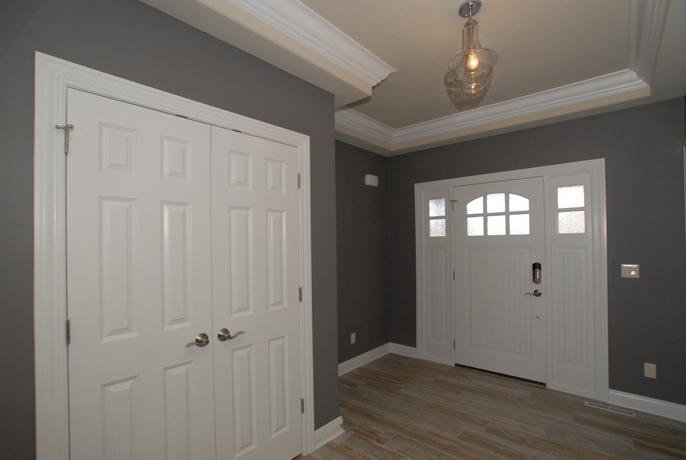 Ispirazione per un ingresso classico di medie dimensioni con pareti grigie, pavimento in gres porcellanato, una porta singola e una porta bianca