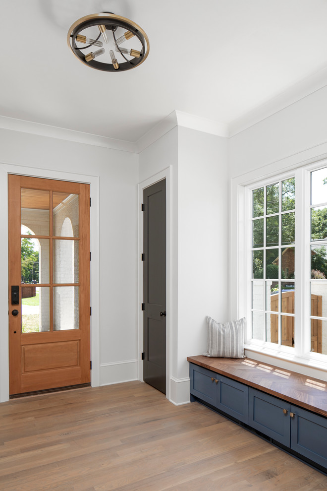 シャーロットにある高級な中くらいなトランジショナルスタイルのおしゃれな玄関ロビー (無垢フローリング、木目調のドア、白い壁、茶色い床) の写真