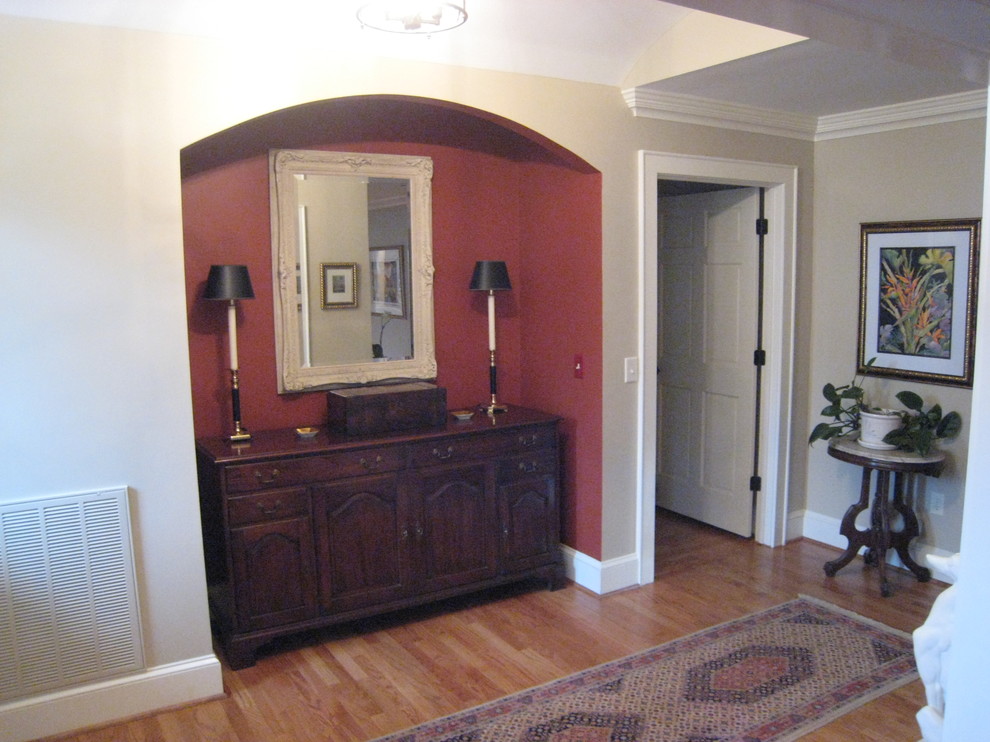 Exemple d'un hall d'entrée chic de taille moyenne avec un mur rouge, parquet clair, une porte simple et une porte blanche.