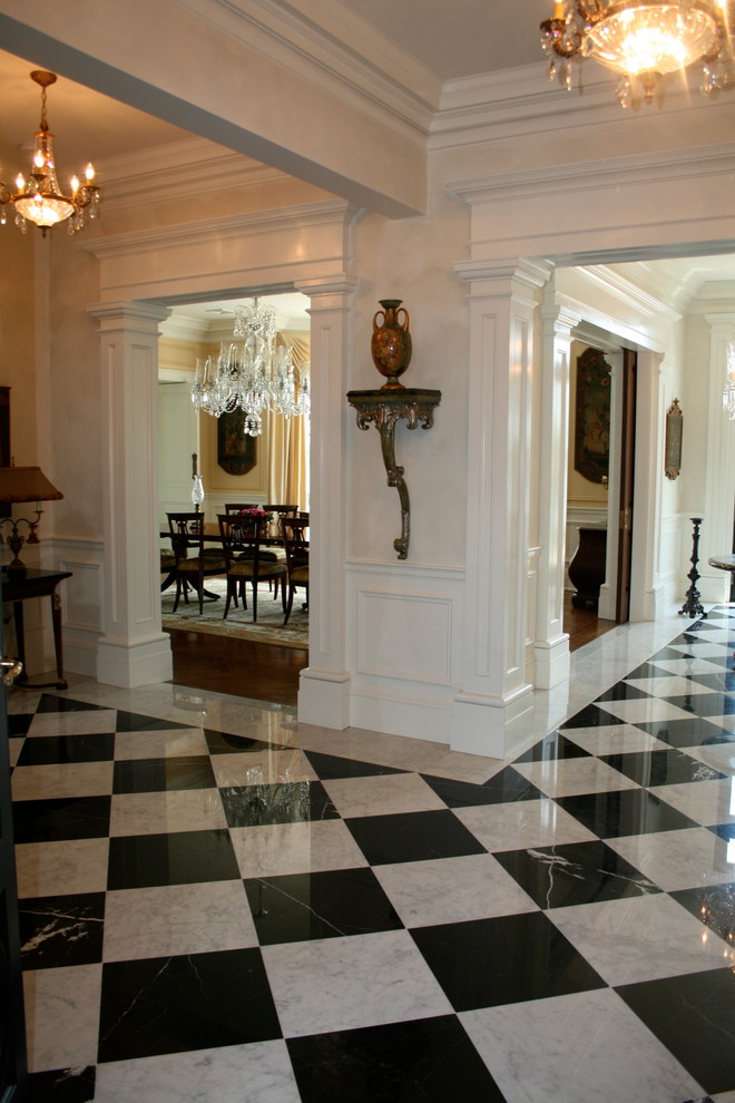 На фото: большое фойе в классическом стиле с белыми стенами, мраморным полом, двустворчатой входной дверью и входной дверью из дерева среднего тона