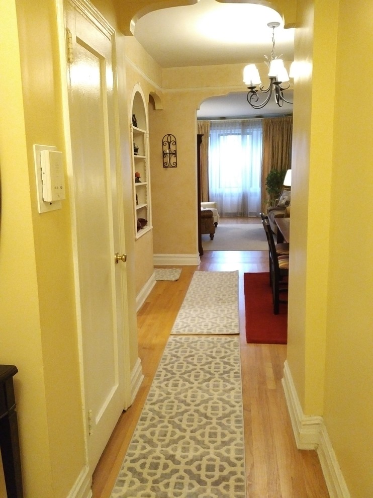Idées déco pour une entrée classique de taille moyenne avec un sol en bois brun, un mur beige, un couloir et un sol marron.