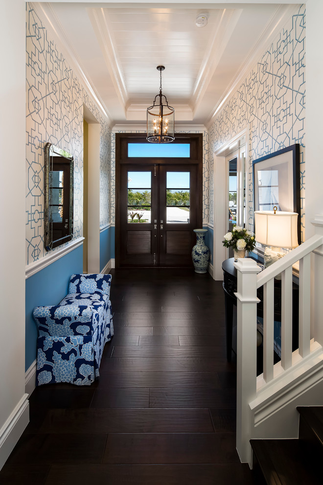 マイアミにある広いトランジショナルスタイルのおしゃれな玄関ロビー (青い壁、濃色無垢フローリング、濃色木目調のドア) の写真