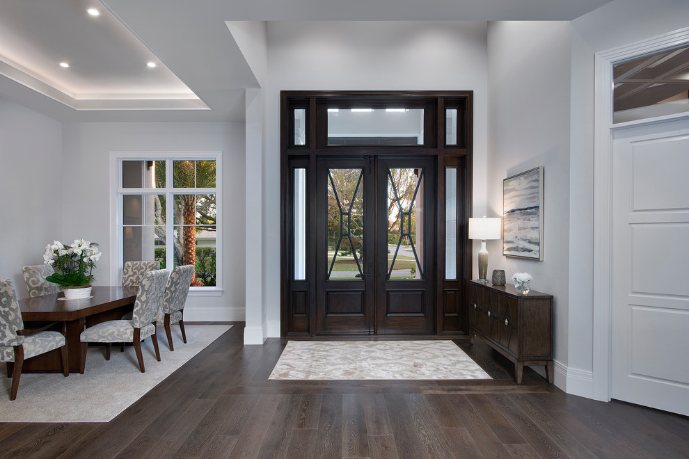 Photo of a large classic foyer in Miami with a double front door, a dark wood front door and feature lighting.