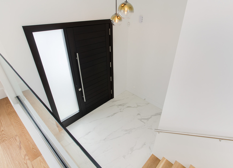Réalisation d'un hall d'entrée minimaliste de taille moyenne avec un mur blanc, un sol en carrelage de porcelaine, une porte simple, une porte en bois foncé et un sol blanc.