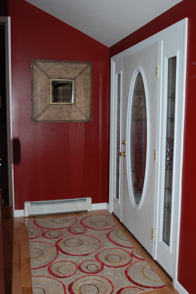 Esempio di un piccolo ingresso classico con pareti rosse, pavimento in legno massello medio e una porta singola