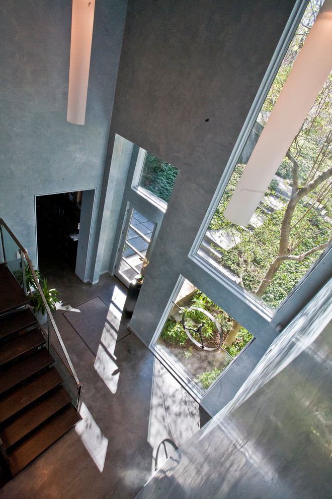 Idéer för en stor modern foajé, med grå väggar, betonggolv, en enkeldörr, glasdörr och grått golv