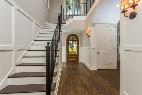 Idee per un corridoio classico di medie dimensioni con pareti grigie, parquet scuro, una porta singola, una porta in legno scuro e pavimento marrone