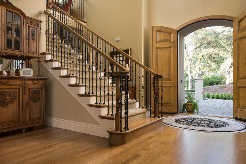 Klassische Haustür mit beiger Wandfarbe, braunem Holzboden, Doppeltür, hellbrauner Holzhaustür und braunem Boden in Sacramento