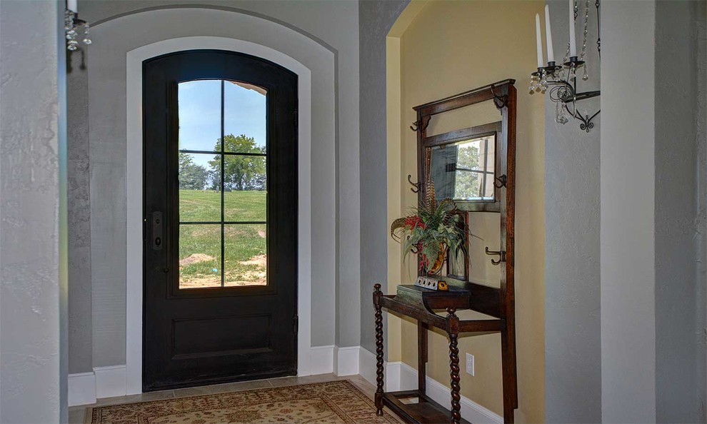 Immagine di una porta d'ingresso boho chic di medie dimensioni con pareti grigie, pavimento in gres porcellanato, una porta singola e una porta nera