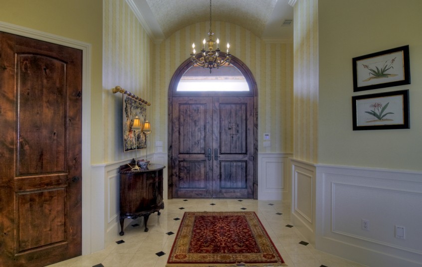This is an example of a medium sized classic front door in Austin with yellow walls, a single front door and a dark wood front door.
