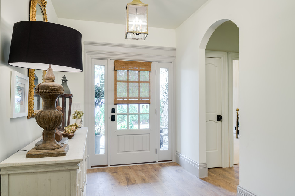 Medium sized front door in Atlanta with white walls, light hardwood flooring, a single front door, a white front door and brown floors.