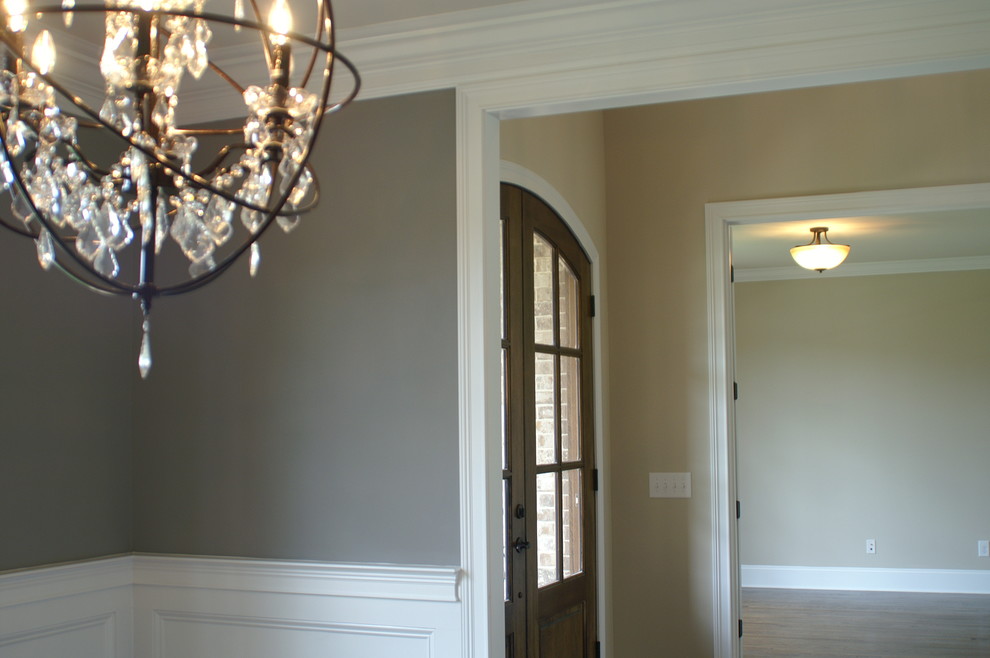 Ispirazione per un corridoio boho chic di medie dimensioni con pareti beige, pavimento in legno massello medio, una porta a due ante e una porta in legno scuro