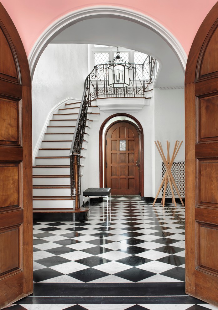 Aménagement d'un grand hall d'entrée éclectique avec un mur gris, un sol en carrelage de céramique, une porte double et une porte en bois foncé.