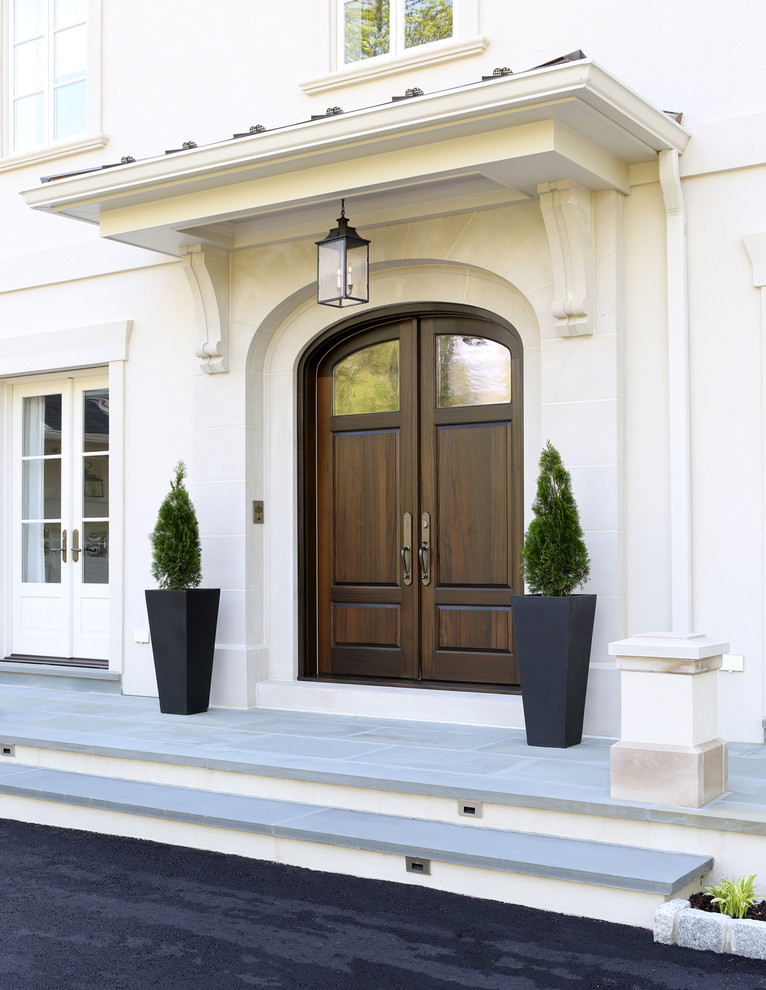 Ejemplo de puerta principal clásica con puerta doble, puerta de madera en tonos medios, paredes blancas y suelo de piedra caliza