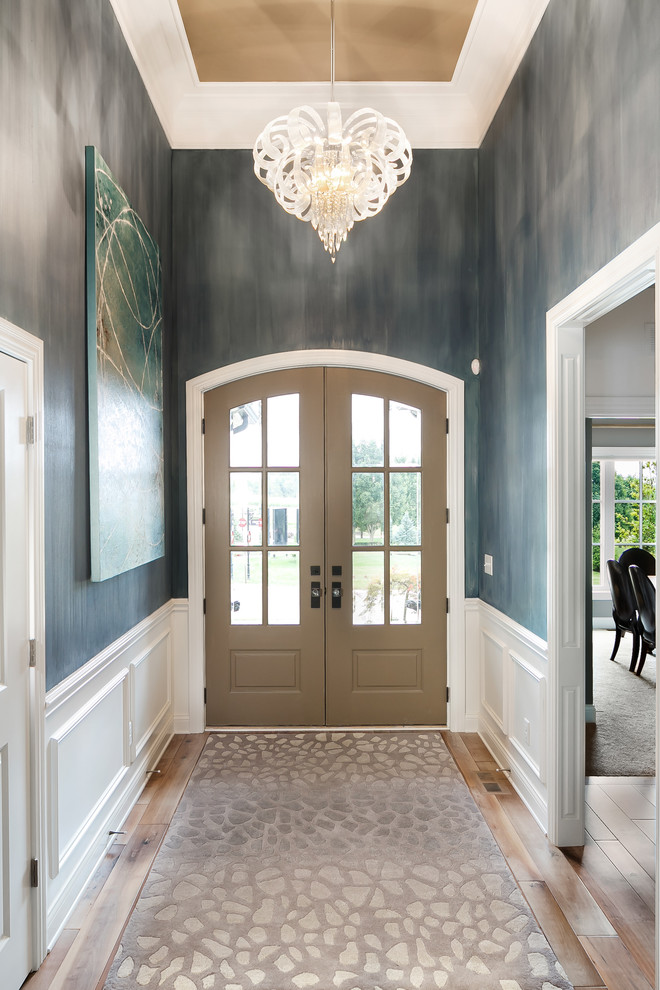 Источник вдохновения для домашнего уюта: фойе среднего размера в стиле неоклассика (современная классика) с синими стенами, паркетным полом среднего тона, двустворчатой входной дверью и коричневой входной дверью