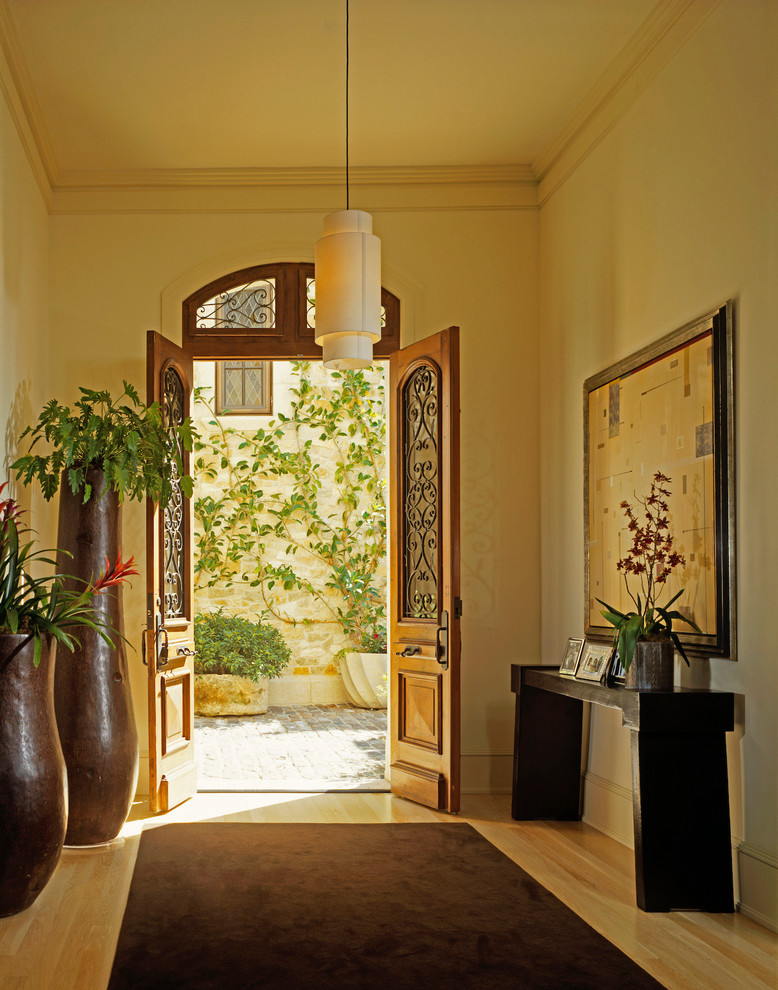 Modelo de entrada mediterránea con puerta doble y puerta de madera en tonos medios